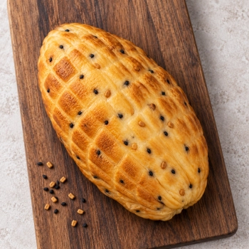 Wędzony ser podpuszczkowy z czarnuszką i kozieradką 350g na ciemnej drewnianej desce